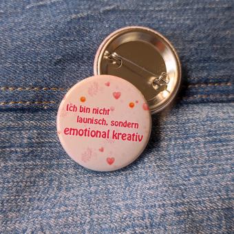 Ansteckbutton Ich bin nicht launisch, sondern emotional kreativ auf Jeans mit Rückseite